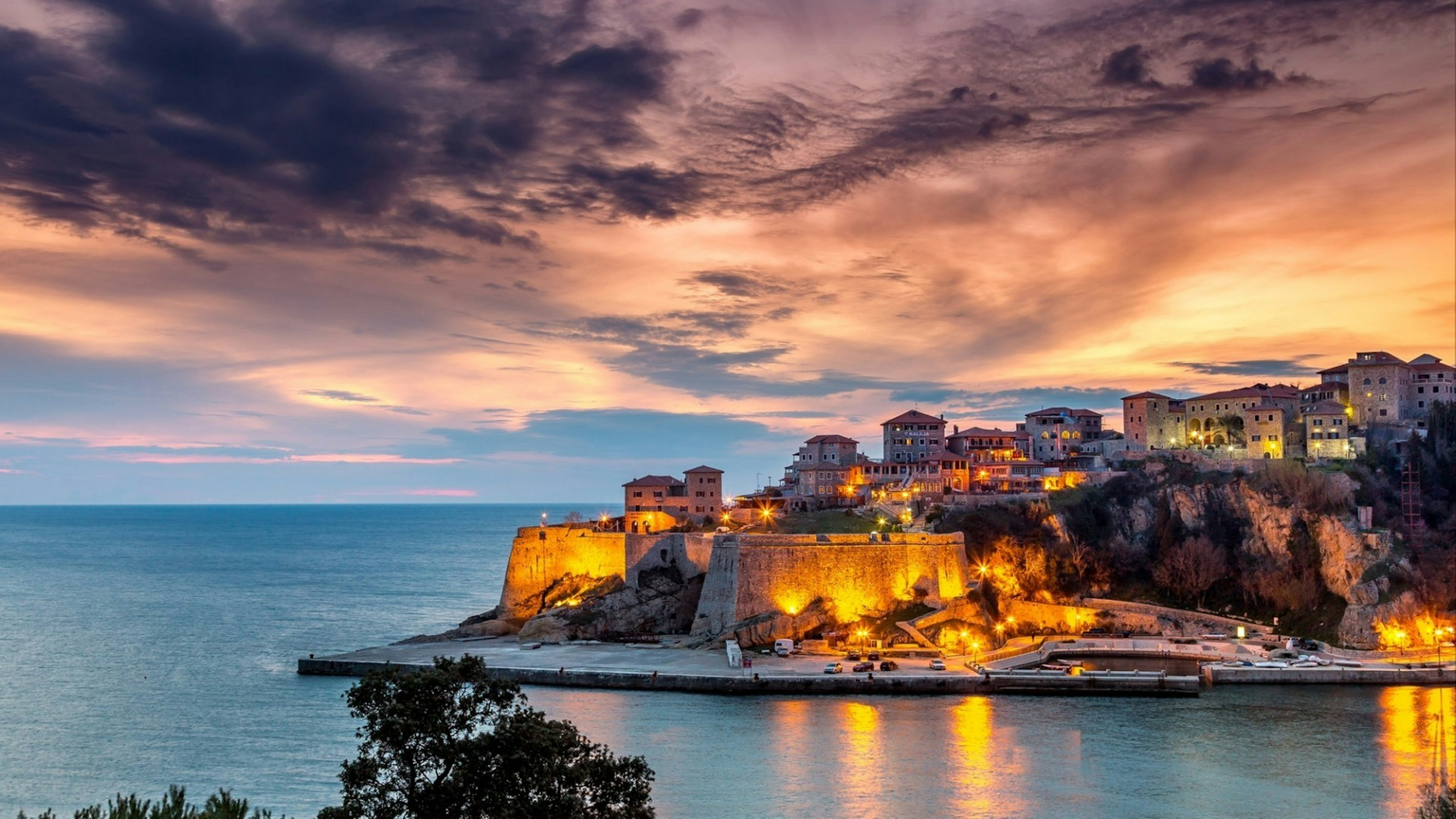 Ulcinj old town fortress with purple after sunset light. Adriatic sea at night in Montenegro.
