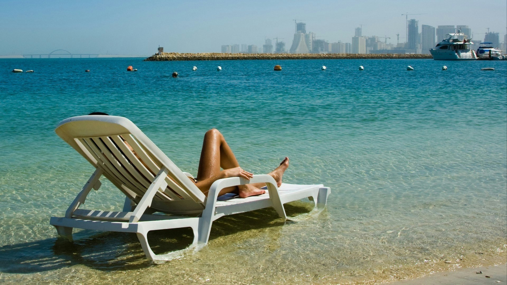 In Bahrain, a young woman rests on a sunbed in the Middle East