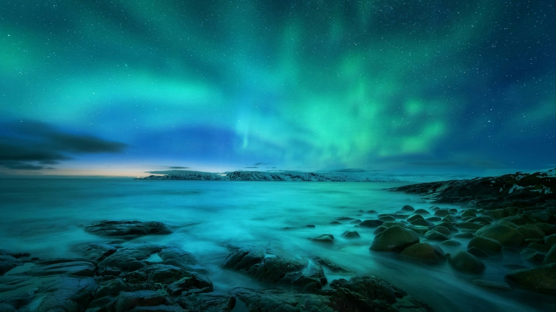 Aurora borealis over rocky beach and ocean. Northern lights in Teriberka, Russia