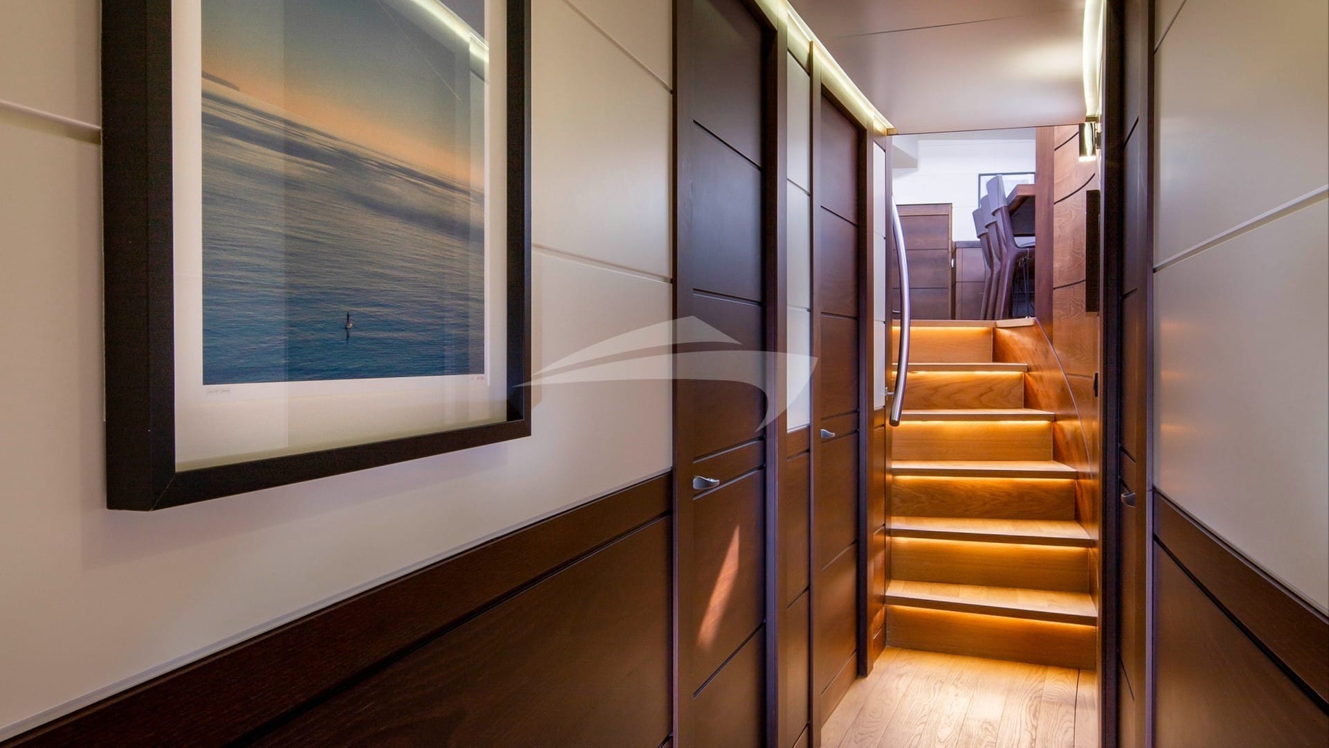 Guest accommodation hallway leading to lower salon; day head on the port side at bottom of stairs