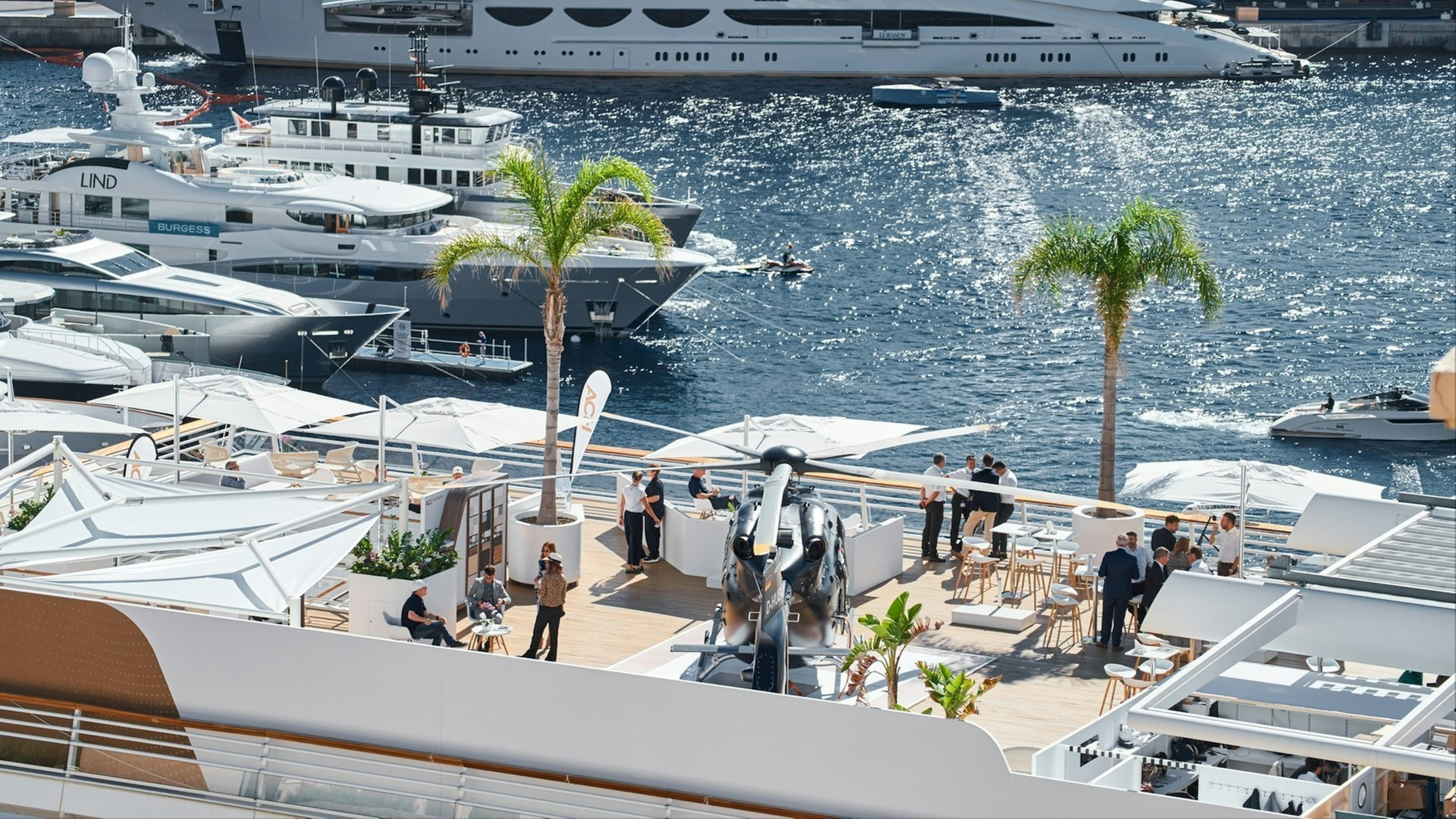 Clients visitors examine a helicopter standing on the deck of a yacht club