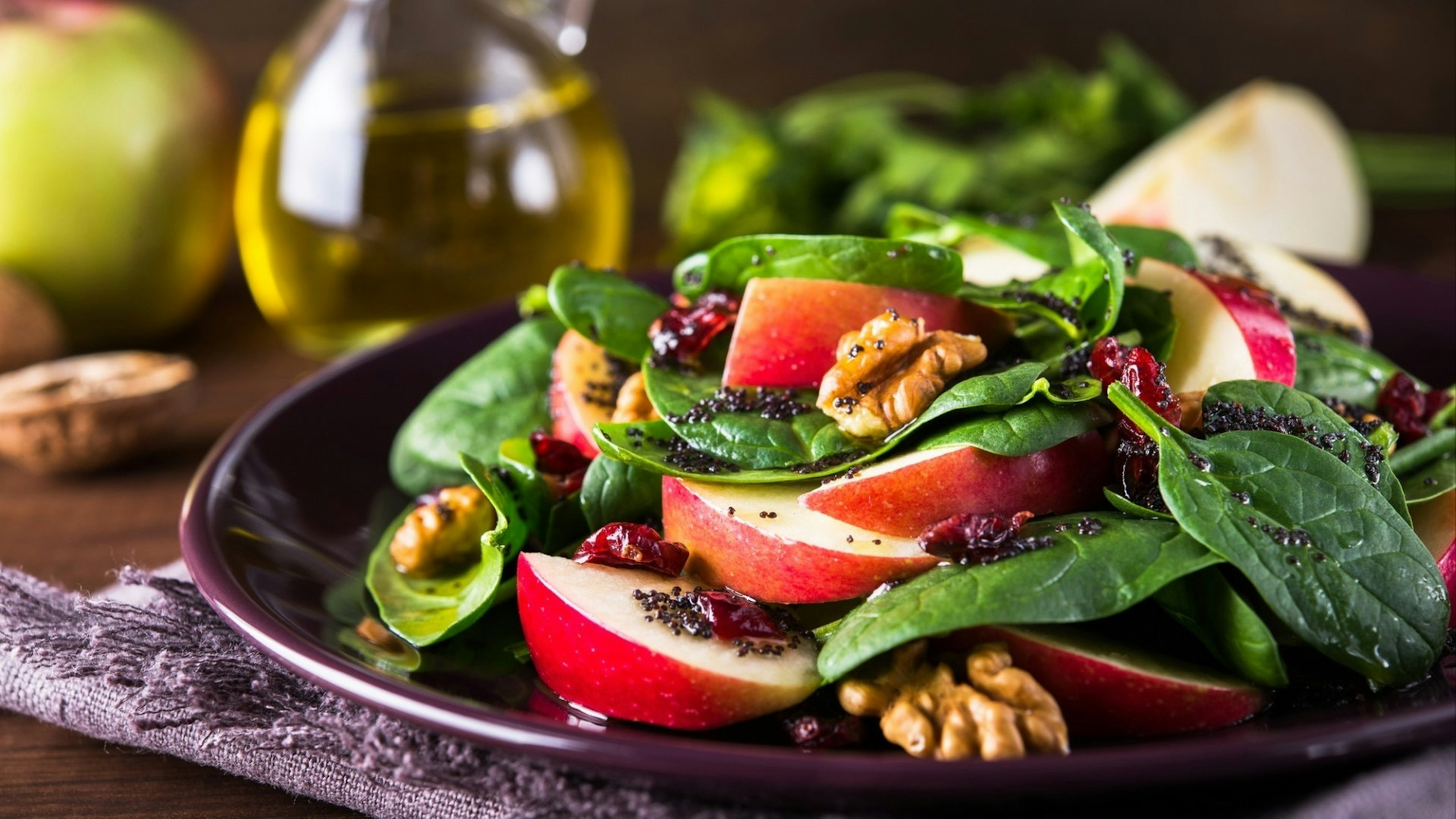 Healthy salad plate with apple, dried cranberry, walnut, spinach