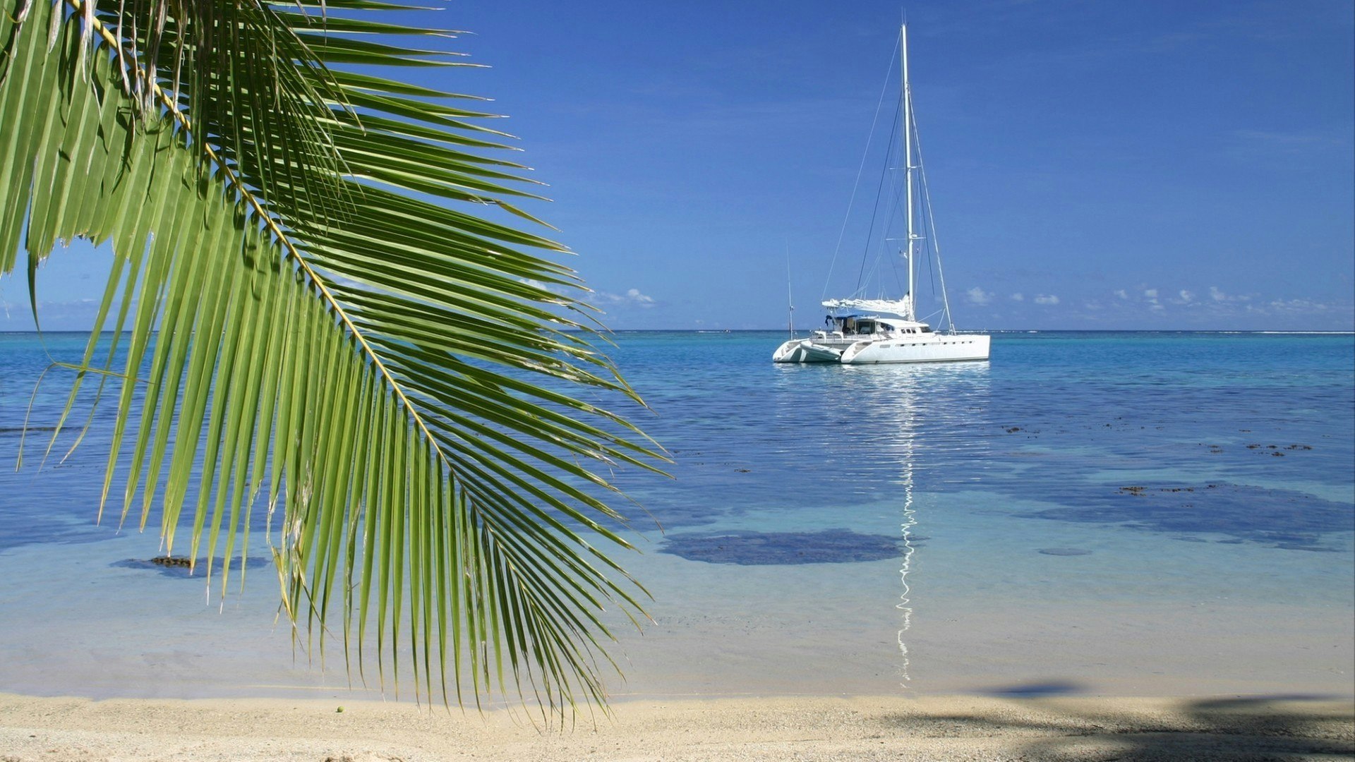 Anchored yacht by the lonely beach. Island Moorea. French Polynesia