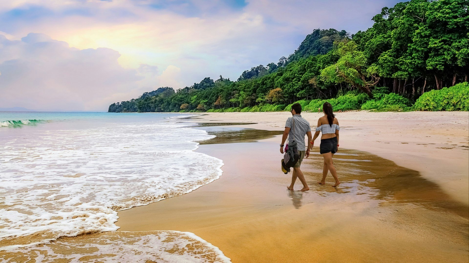 Honeymoon couple take a walk at the scenic Havelock islands beach at Andaman